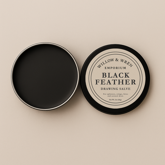 Black Feather drawing salve container with lid open on a beige background